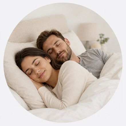 Couple sleeping peacefully side by side in bed, illustrating quieter nights with Snorbliss